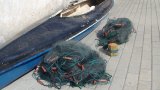 przedmioty zabezpieczone przez policjantów: kajak w kolorze niebiesko - białym i dwie sieci rybackie