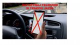 w śrdoku samochodu w ręce telefon komórkowy i napis nie używaj telefonu w trakcie jazdy