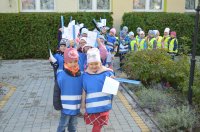grupa przedszkolaków ubrana w niebieskie kamizelki odblaskowe