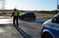 radiowóz, policjant zatrzymuje pojazd do kontroli drogowej