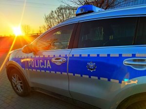 radiowóz policyjny na tle zachodzącego słońca