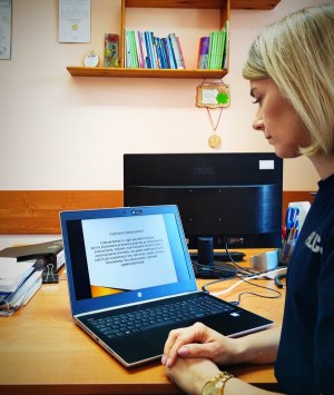 młodszy aspirant Edyta PAcuk siedząca przed laptopem i prowadząca lekcje on-line