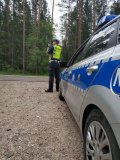 policjant ruchu drogowego przy użyciu miernika prędkości dokonuje pomiaru