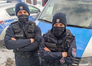 policjanci na tle radiowozów