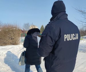 policjant wraz z pracownikiem socjalnym niesie paczkę