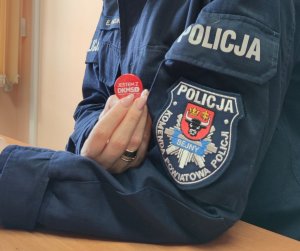 policjantka trzymająca znaczek fundacji DMKS