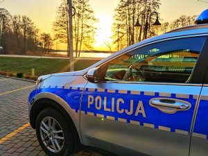 radiowóz sejneńskiej policji na tle zachodzącego słońca