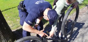 policjant sprawdzający ramę roweru