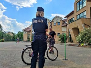 policjantka podczas egzaminu na kartę rowerową na placu przed szkołą