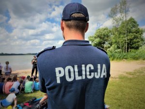 policjant w mundurze patrzący na grupę dzieci