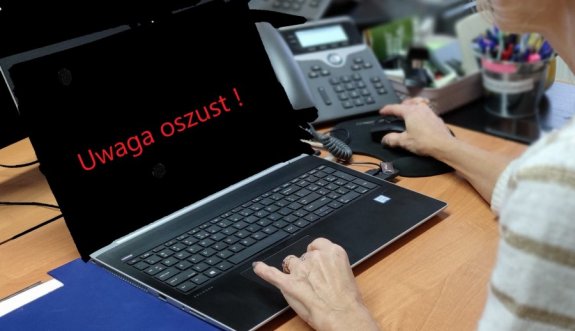 laptop na ekranie napis uwaga oszust