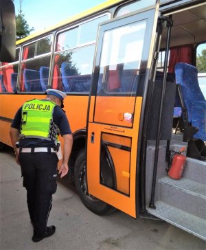 policjant ruchu drogowego kontroluje autobus