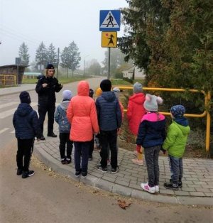 policjantka przed przejściem dla pieszych rozmawiająca z dziećmi