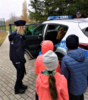 policjantka pokazująca dzieciom wnętrze radiowozu