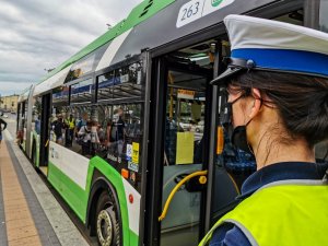 umundurowana policjantka stojąca przy autobusie