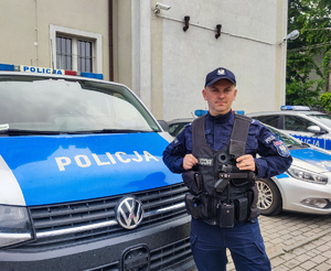 policjant stojący przy radiowozie