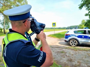 umundurowany policjant dokonuje pomiaru prędkości